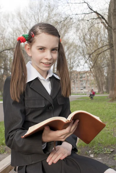 十几岁的女孩拿着一本书在一个公园 — 图库照片