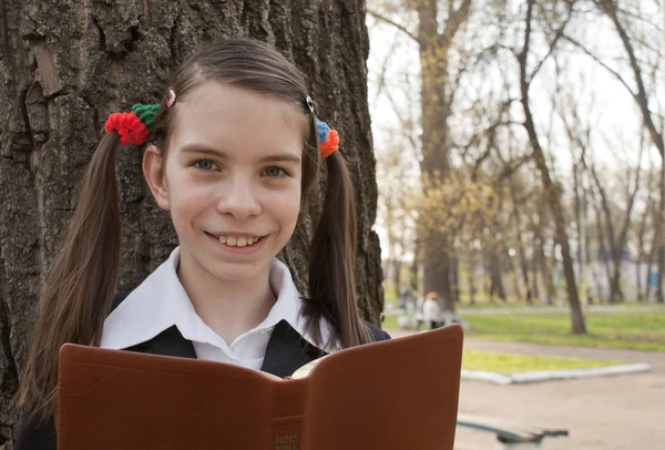 Menina adolescente com a Bíblia em um parque — Fotografia de Stock