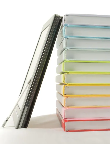 Пачка красочных книг и электронный читатель книг на белом фоне — стоковое фото