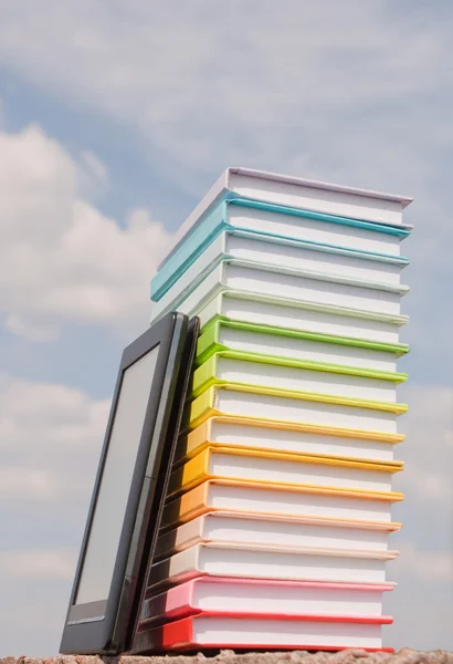 Renkli kitaplar ve elektronik kitap okuyucu açık havada yığını — Stok fotoğraf