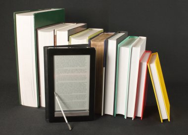 Row of printed books with electronic book reader on black background clipart