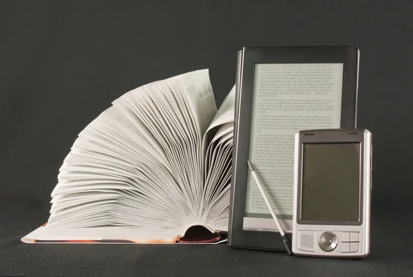 Libro abierto, lector de libros electrónicos y computadora de mano sobre fondo negro —  Fotos de Stock