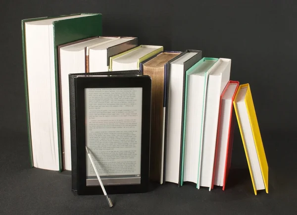 Rij van gedrukte boeken met elektronische boek lezer op zwarte achtergrond — Stockfoto