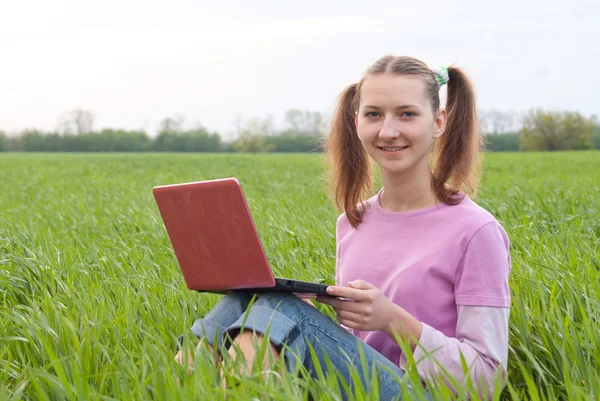 Dospívající dívka s notebookem sedět venku — Stock fotografie