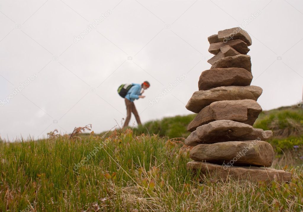 Stack of stones with teen girl tourist on background