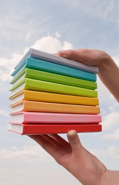 Mani che tengono libri di copertina rigida a colori — Foto Stock