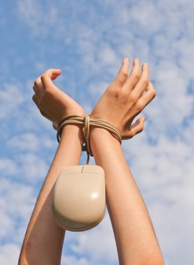 Hands tied up with a computer mouse cord - office slavery concept clipart