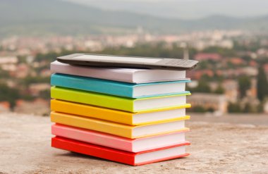 elektronik kitap okuyucu ile renkli kitap yığını
