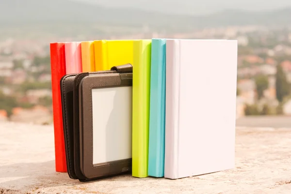 Řada barevných knih s čtečkou elektronických knih — Stock fotografie
