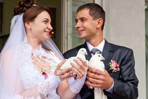 Glücklicher Bräutigam und Braut mit Hochzeitstauben — Stockfoto