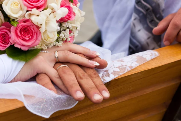 Hände und Ringe mit Brautstrauß — Stockfoto