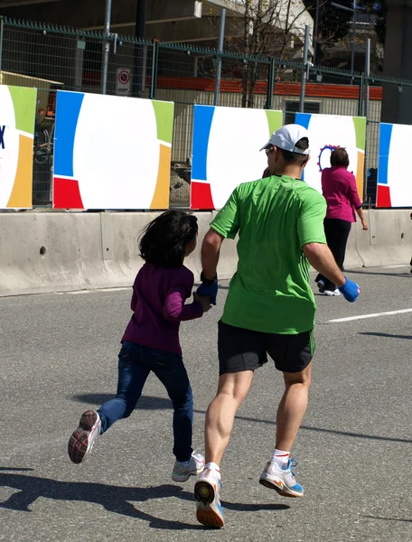 Папа и дочь бегут к финишу марафона — стоковое фото