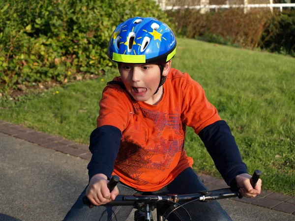 Engraçado menino na bicicleta com capacete — Fotografia de Stock