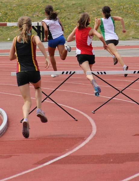 Girls running 200 meter hurdles — Stock Photo, Image