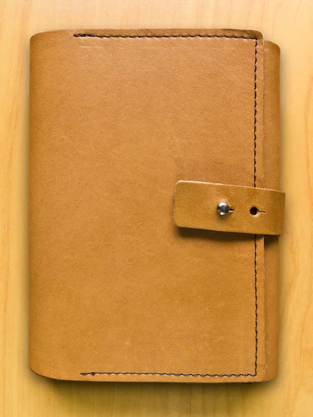Кожаный чехол ноутбук на деревянном фоне — стоковое фото