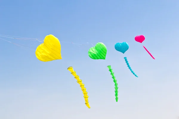 カラフルな愛の心の凧は青い空を背景 — ストック写真