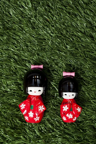 Bonecas japonesas isoladas em grama verde falsa — Fotografia de Stock