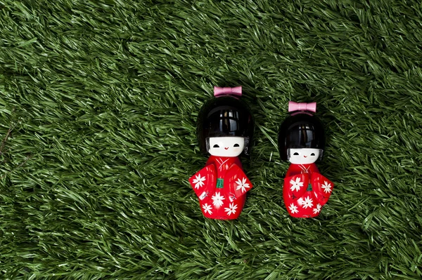 Japnaese dolls isolated on fake green grass — Stock Photo, Image