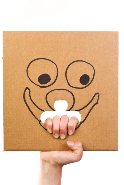 Cardboard with sketch of smiling face in hand — Stock Photo, Image