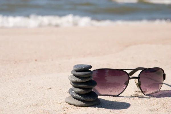 Pebble stack and sunglasses — Stock Photo, Image