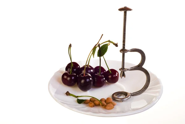 Cherries and pitter on plate — Stock Photo, Image