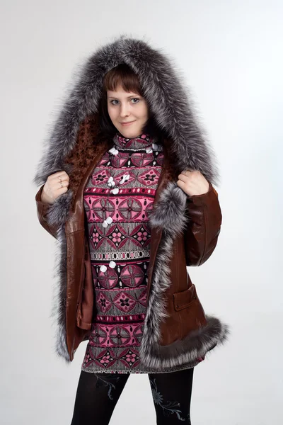 Молодая женщина, стоящая в пальто с меховой шеей изолированы — стоковое фото