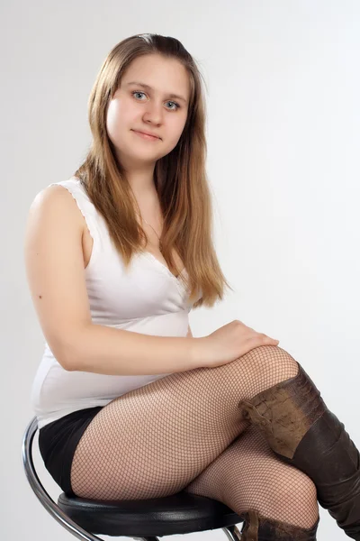 Vrouw in korte broek en t-shirt zittend op stoel — Stockfoto