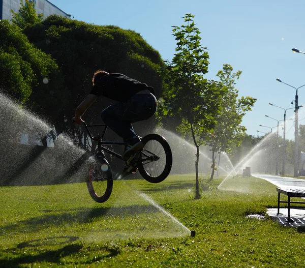 Boy jumping over fountain on bmx — Stock Photo, Image