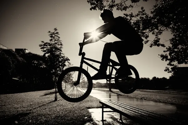 Boy jumping over bench on bmx — Stock Photo, Image