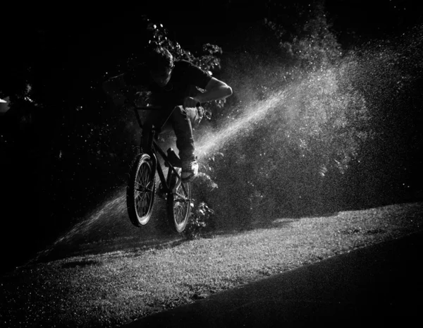 Chlapec skákání přes fontánu na bmx — Stock fotografie