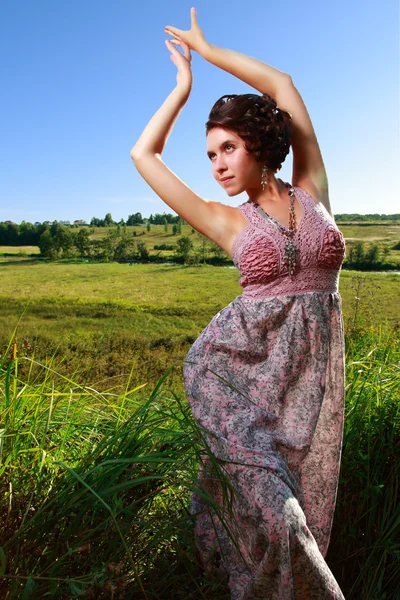 Mooi meisje in jurk op veld — Stockfoto