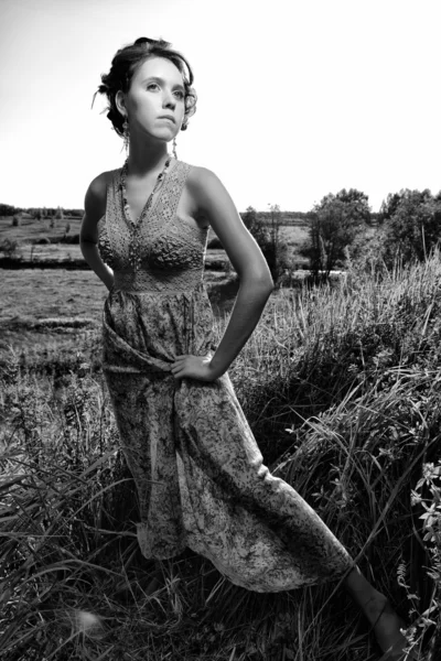 Vacker flicka i klänning på fältet — Stockfoto