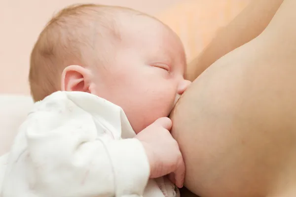 母乳喂养刚出生的婴儿。在母亲怀中吃奶的孩子 — 图库照片