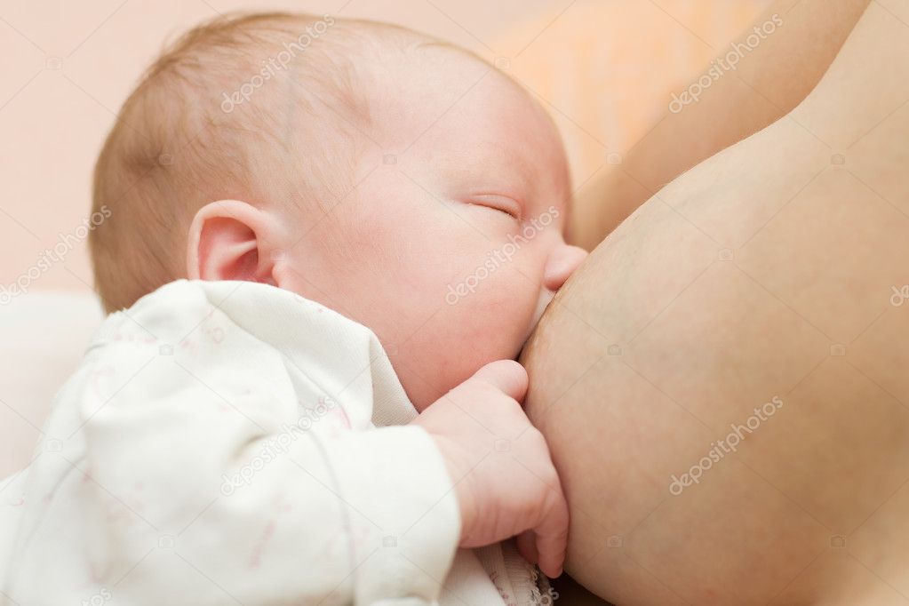 Breast-feeding a newborn baby. The kid in its mother's breast