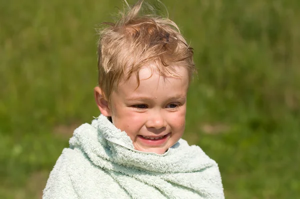 A boy of four years, wrapped in a towel after bathing in the riv — Stock Photo, Image