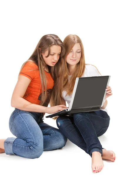 Две молодые счастливые студентки работают на ноутбуке — стоковое фото