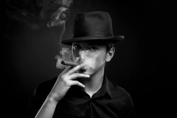 Чоловік з капелюхом і сигаретою в чорному — стокове фото