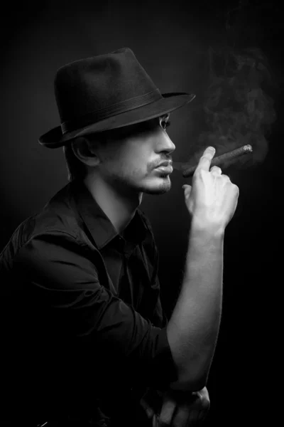 Man med hatt och cigarr i svart — Stockfoto