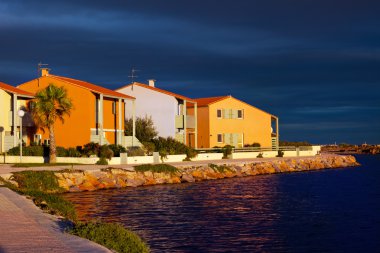 Seaside vacation village at sunset, France clipart