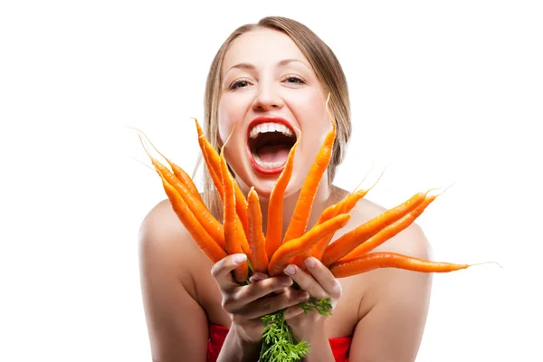 Mulher atraente mantém um monte de cenouras — Fotografia de Stock