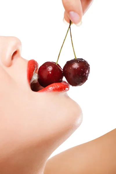 Young woman's mouth with red cherries Royalty Free Stock Images