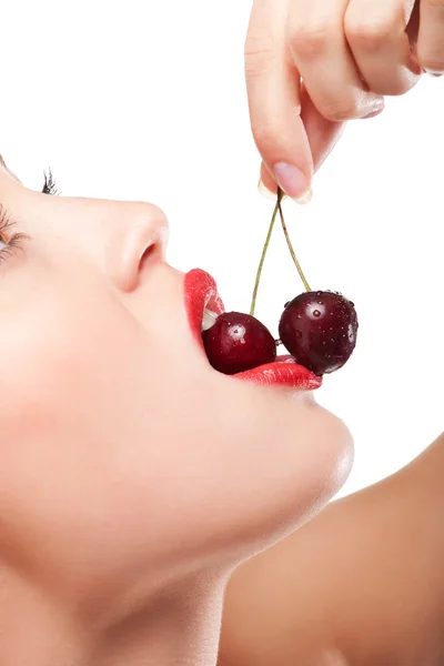 Young woman's mouth with red cherries Stock Photo