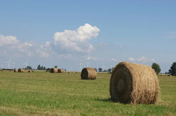 Větrné turbíny a seno balíky v oboru — Stock fotografie