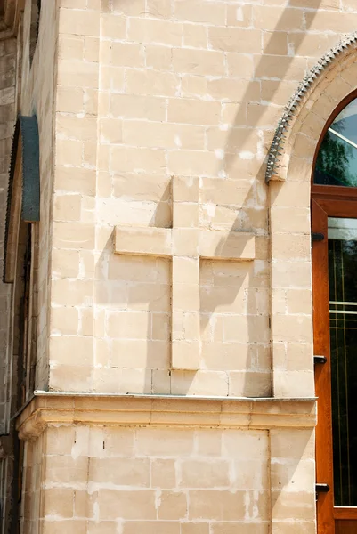 Cross på kyrkliga väggen. — Stockfoto