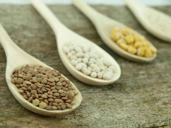 Legumes over spoons — Stock Photo, Image