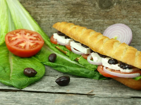 Mediterranean baguette with olives — Stock Photo, Image