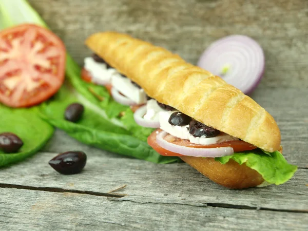 Mediterranean baguette with olives — Stock Photo, Image