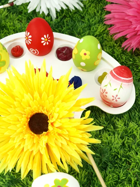 Цветы и пасхальные яйца на палитре — стоковое фото