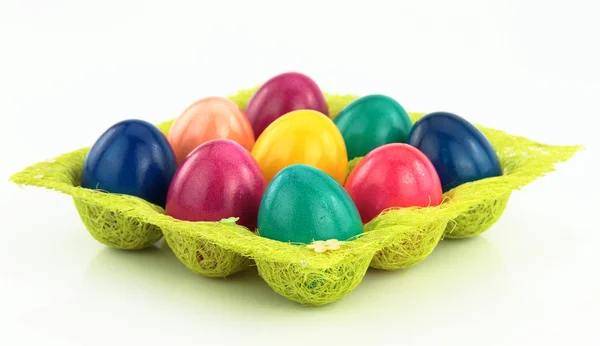 Цветные пасхальные яйца в футляре с декоративными травяными яйцами — стоковое фото