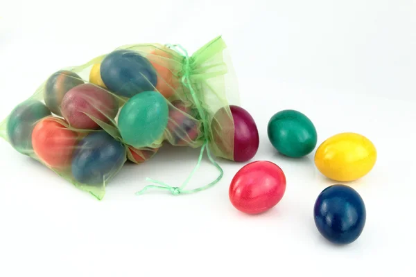 Цветные пасхальные яйца в зеленой сумке тюля — стоковое фото